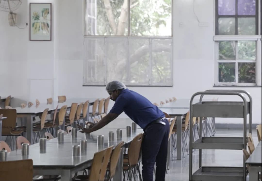 Student studying at a wooden desk in a comfortable residential boarding room at Sarala Birla Academy